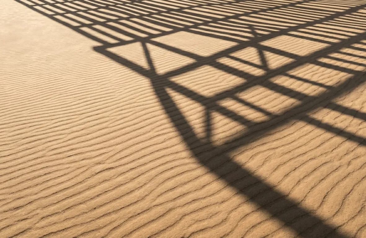 Sand and shadow grid pattern representing structured AI systems